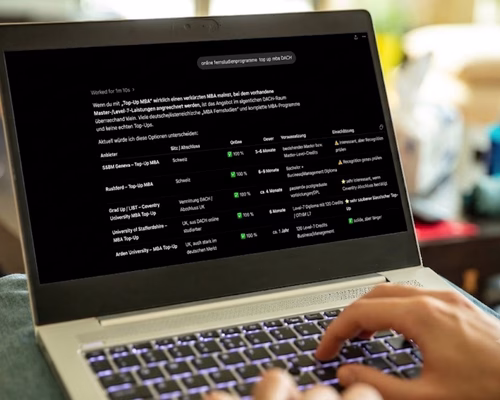 Person arbeitet am Laptop und analysiert eine strukturierte Tabelle zu Top-Up MBA Fernstudienprogrammen im DACH-Raum im Dark-Mode